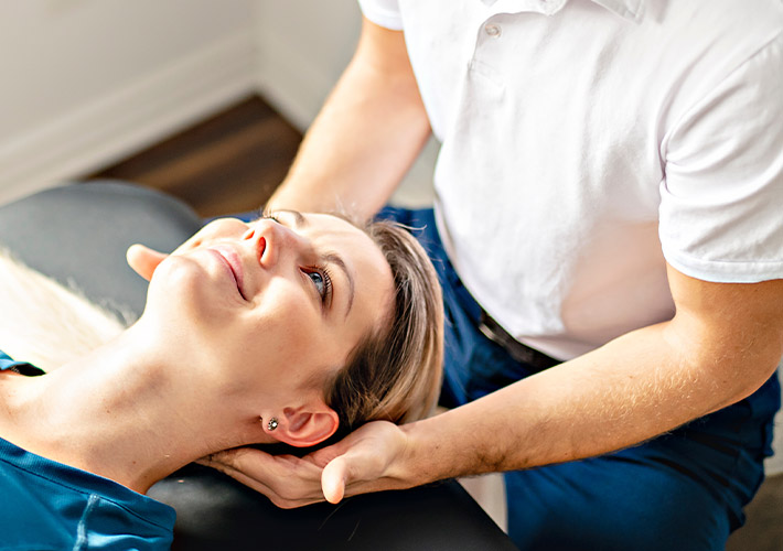 Chiropractor treating female patient for neck pain